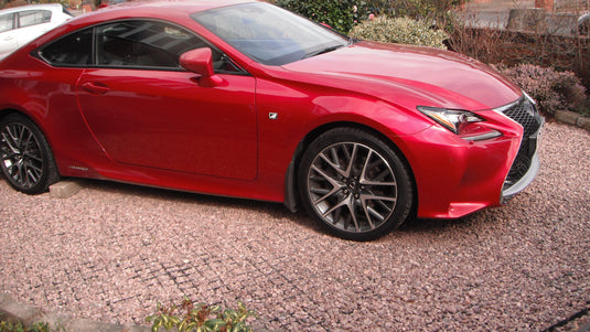 Red car parking on reinforced gravel driveway